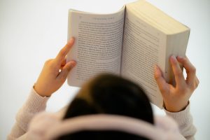 Photo by Jairo Gonzalez woman in white long sleeve shirt reading book