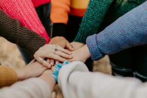 Photo by Hannah Busing person in red sweater holding babys hand